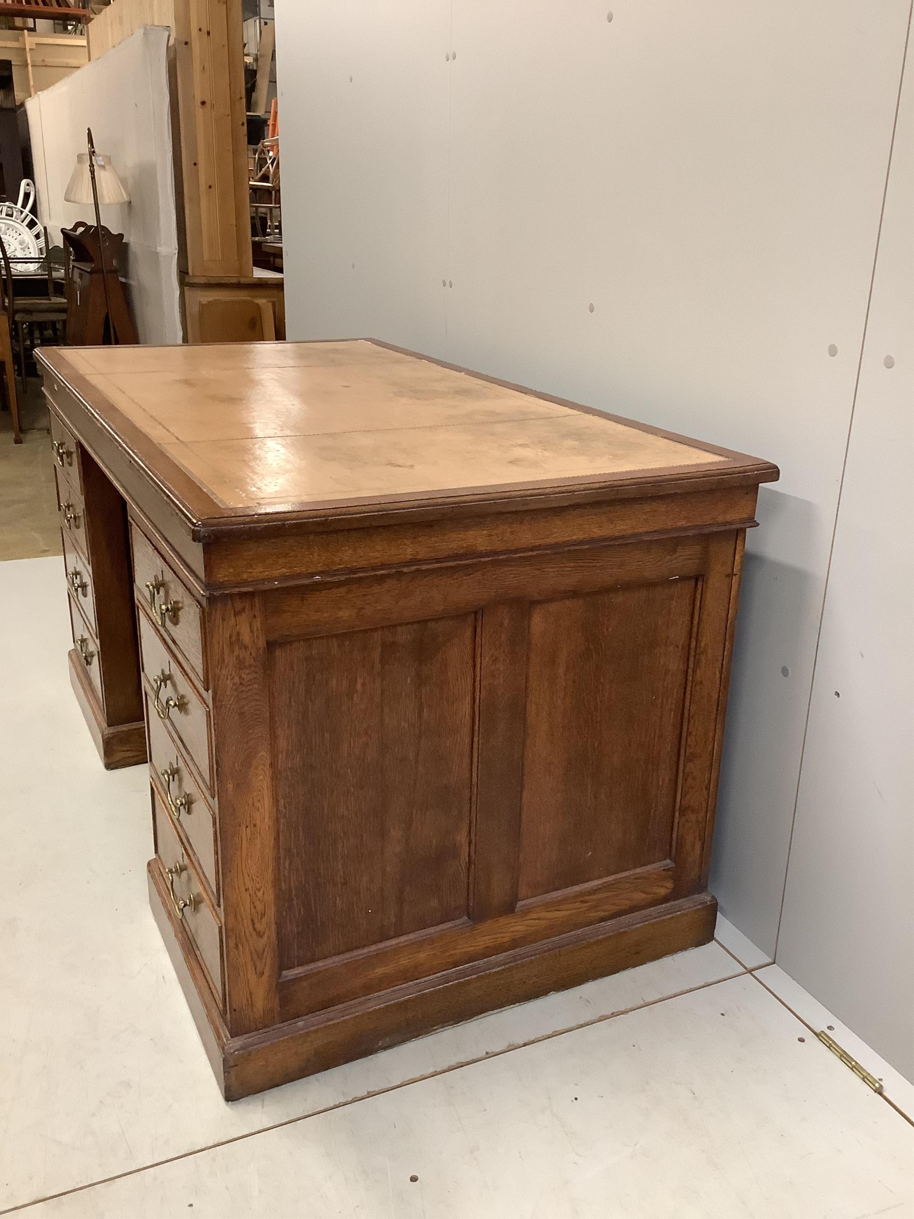 An early 20th century oak pedestal desk, bears George V cypher and stamped John Walsh Ltd Sheffield, width 142cm, depth 75cm, height 75cm. Condition - fair